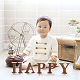 男の子がHAPPYと書いた置物の後ろに座っている様子