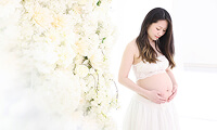 妊婦が大きく膨らんだお腹を愛おしそうに見つめる様子