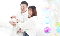 夫婦が新生児を一緒に抱っこしている様子