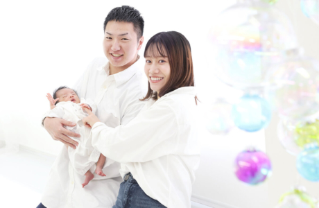 夫婦が新生児を一緒に抱っこしている様子