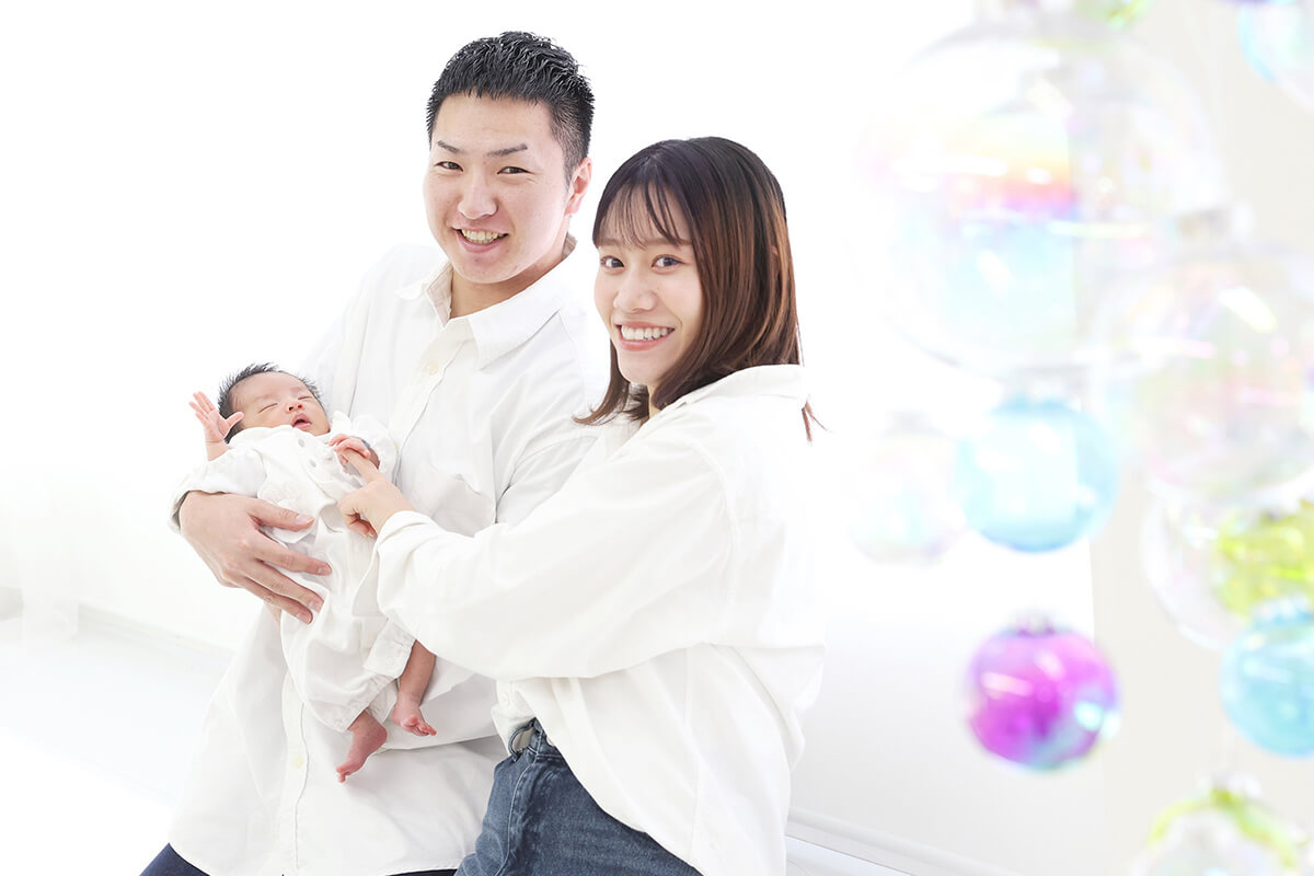 夫婦が新生児を一緒に抱っこしている様子