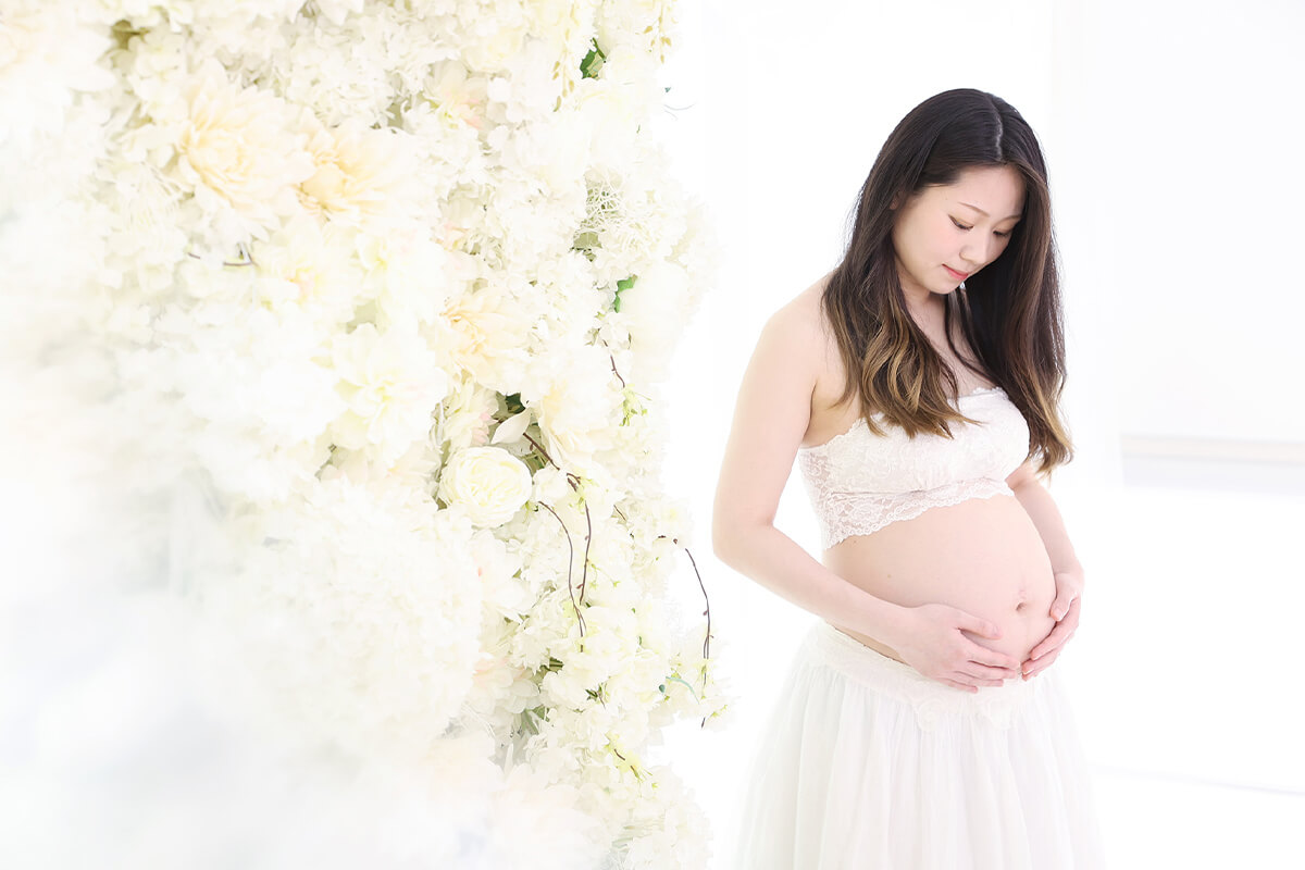 妊婦が大きく膨らんだお腹を愛おしそうに見つめる様子
