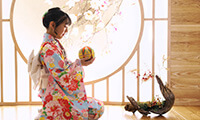着物を着た女の子が手毬で遊んでいる様子