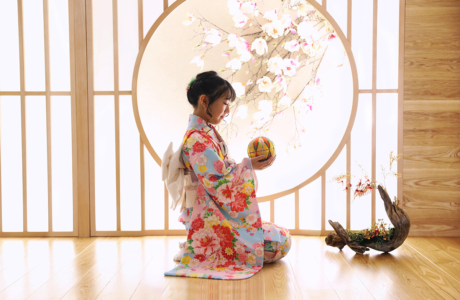 着物を着た女の子が手毬で遊んでいる様子