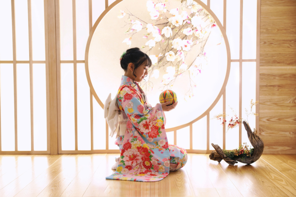 着物を着た女の子が手毬で遊んでいる様子